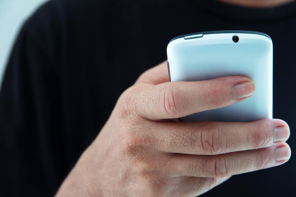 Foto de una persona utilizando un teléfono de color azul aguamarina