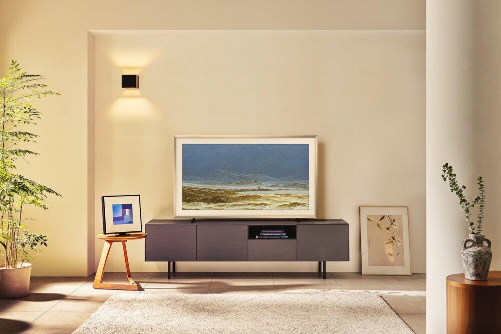 Foto de una sala con un televisor con una mesa y un fondo color pastel