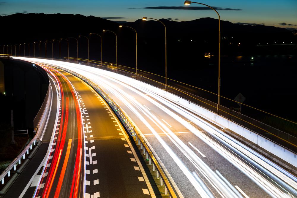 Foto de una vía con efecto de cámara, los carros se ven como luces de varios colores