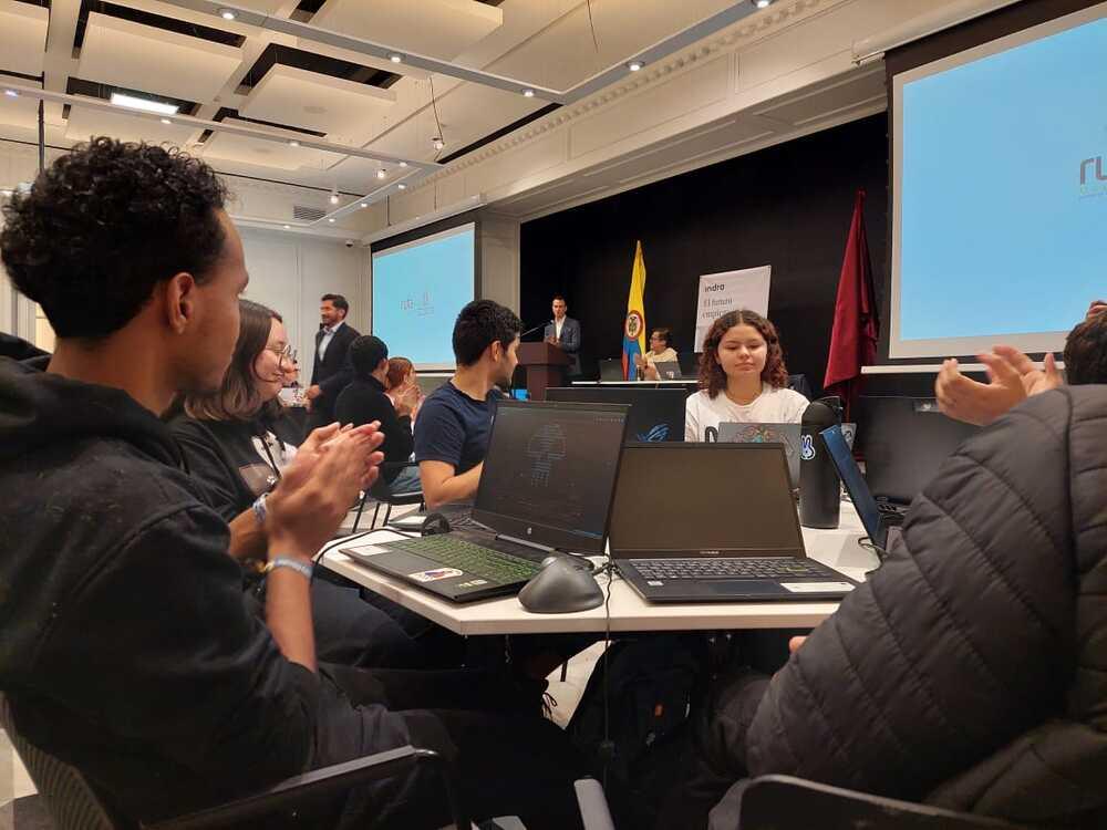 Foto de varias jóvenes sentados en una mesa mirando el computador