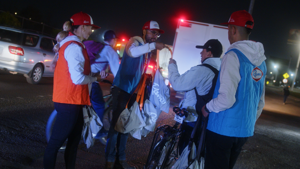 Foto de varias personas entregando kits en la calle