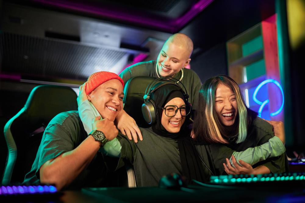 Foto de varias personas jóvenes jugando frente a un pc