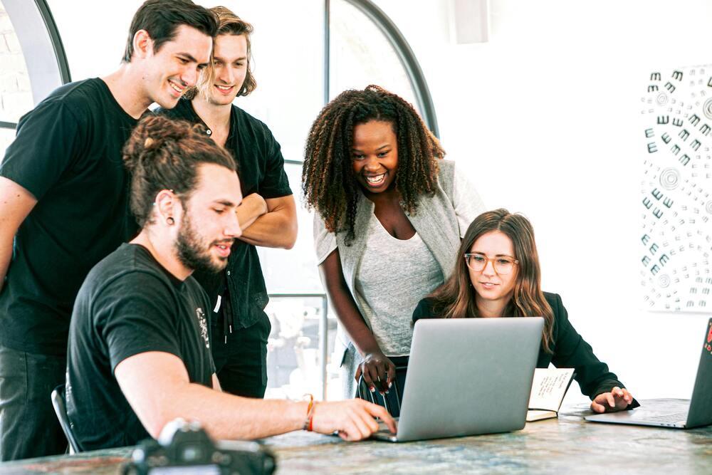 Foto de varias personas reunidas frente a un computador