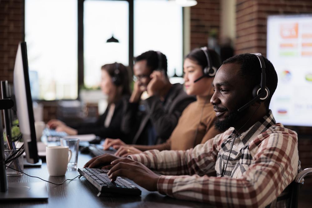 Foto de varias personas trabajando en una emrpesa frente al computador