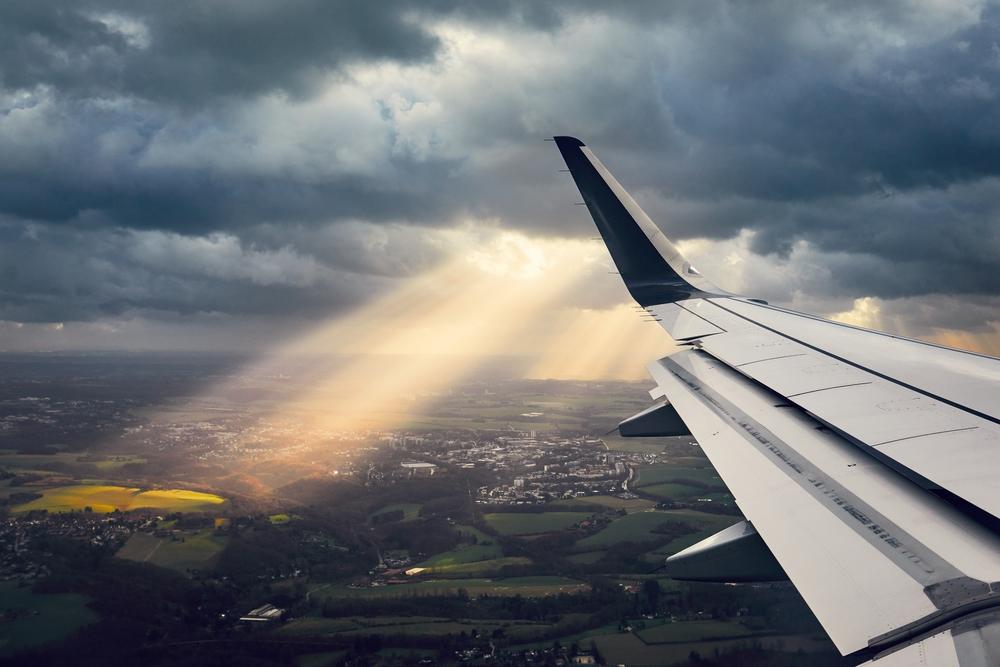 Foto del ala de un avión con un fondo terrestre