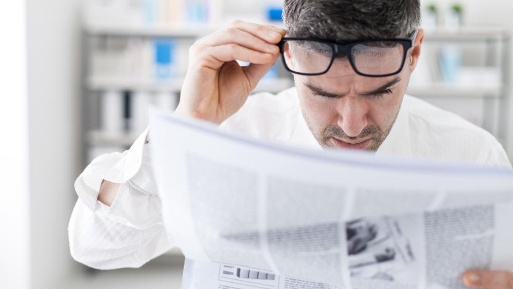 Fotografía de una persona mirando un periódico