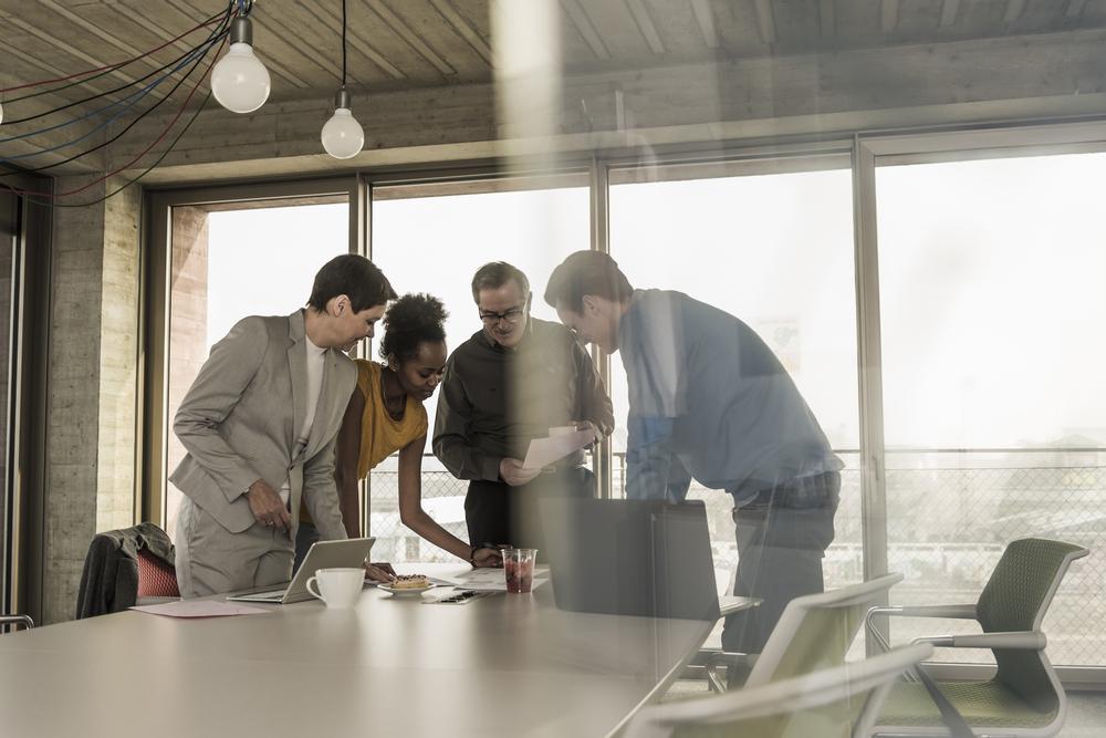 Fotografia de un equipo de trabajo hablando sobre una mesa