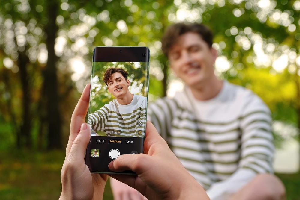 Fotografia de una persona dentro del encuadre del celular con fondo verde