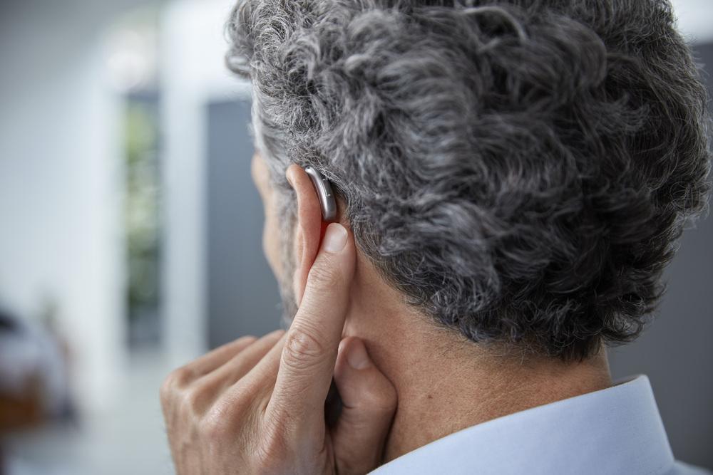 Foto de hombre con dispositivo auditivo en el oido izquierdo