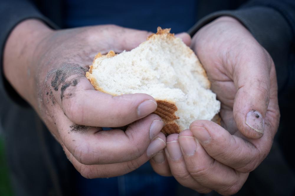 Imagen de una persona con un pan en la mano.