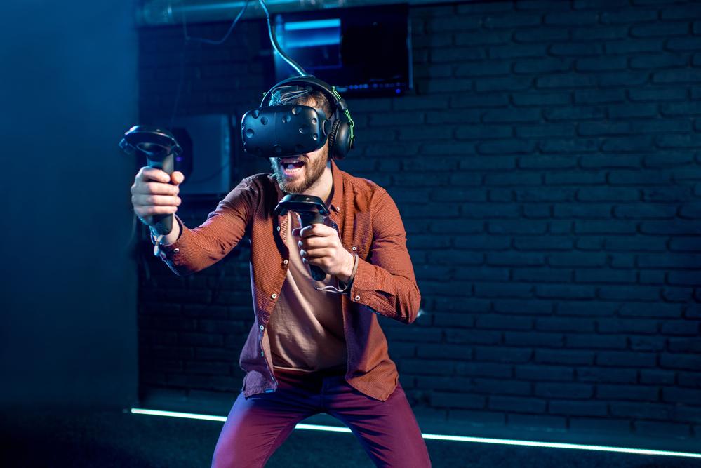 Hombre jugando con gafas de realidad aumentada con un fondo azul