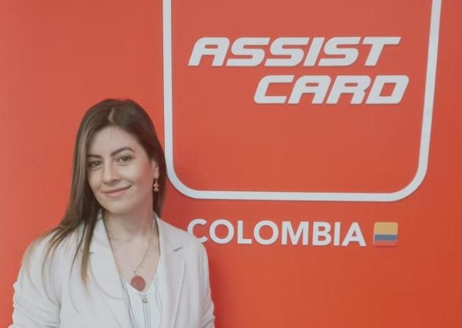Foto de una mujer trigueña sonriendo a la cámara con un fondo que dice: Assist Card