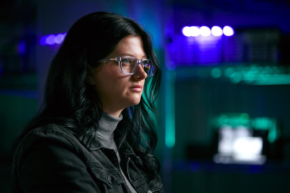 Mujer con gafas de perfil, pelo negro, viendo una pantalla