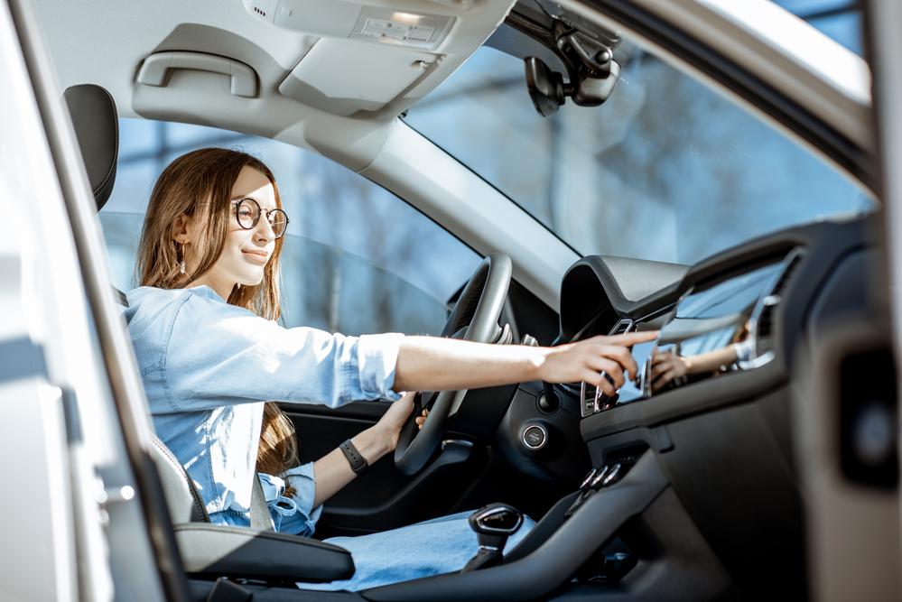 Mujer en el carro cambiando de estación de radio