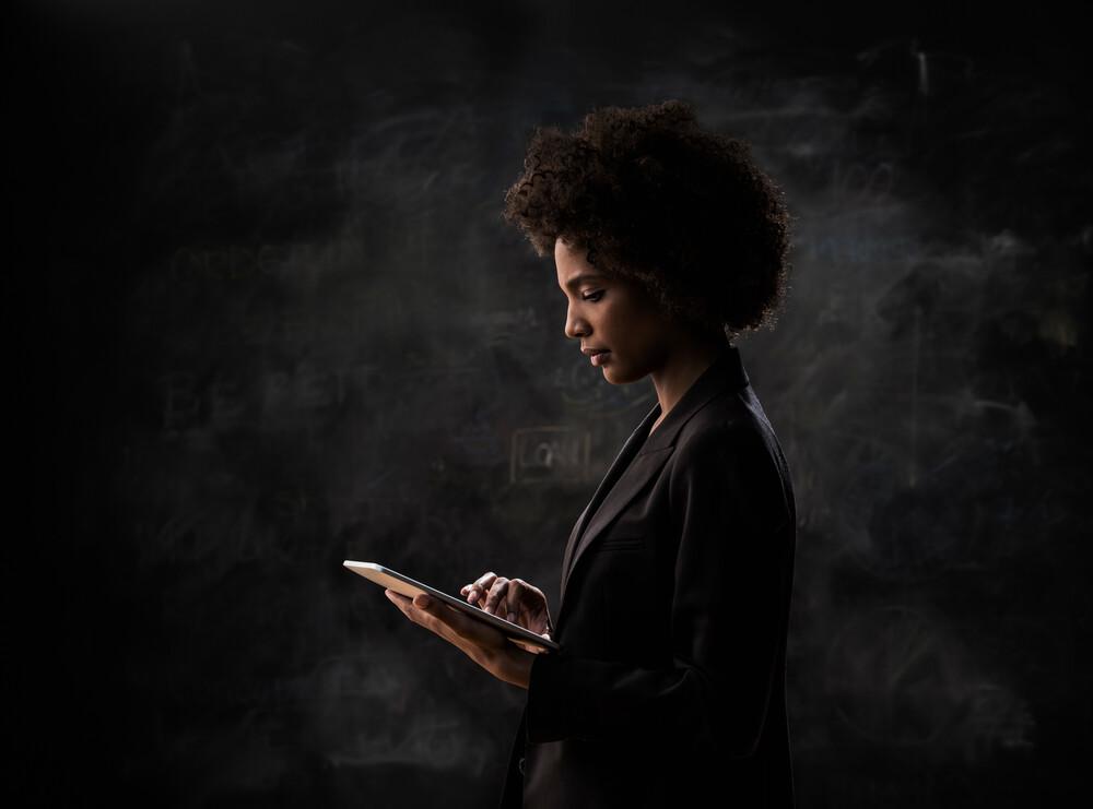 Mujer mirando computador con fondo negro