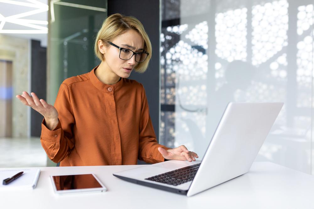 Mujer quejandose al frente de un computador