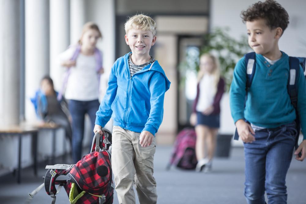 Foto de dos niños caminando en una escuela