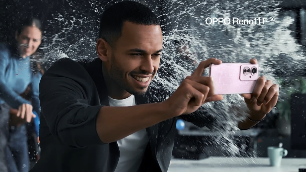 Foto de una persona utilizando un celular con una bomba de agua estallando en su cabeza