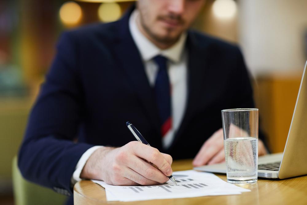 hombre escribiendo sobre un papel