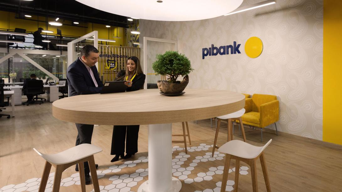 dos personas hablando en una oficina de Pibank