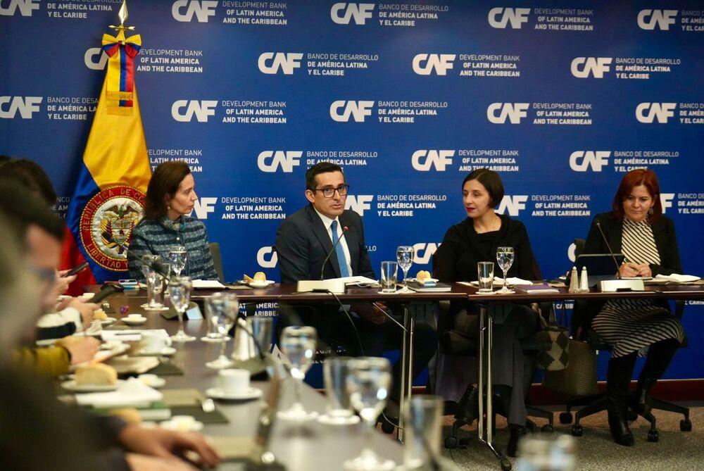 Reunión de cuatro personas sentadas en una mesa conversando