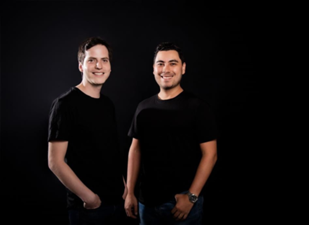 Foto de dos hombres con camiseta negra sonriendo a la cámara