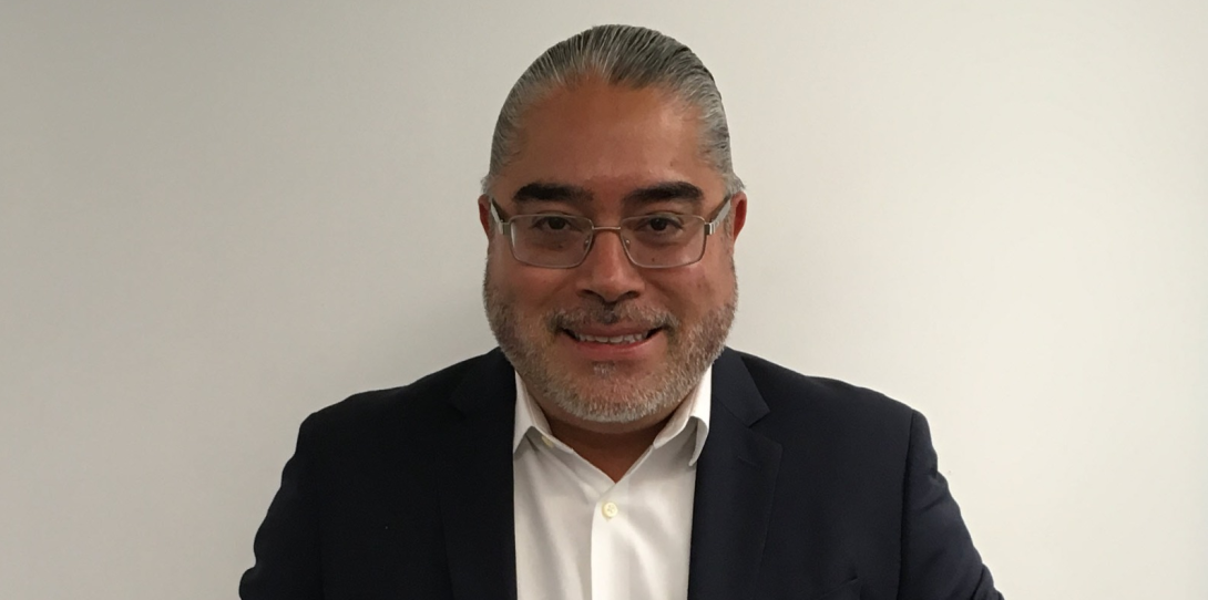 Foto de un señor con gafas blancas, mirando a la cámara con pelo hacía a trás