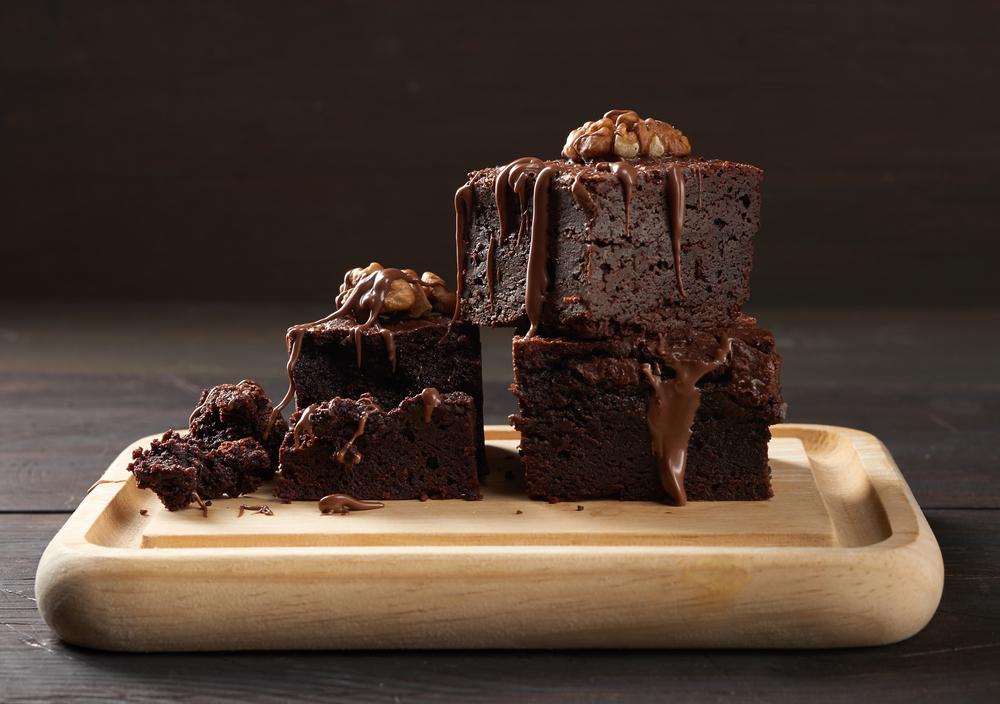 Torta de chocolate sobre una tabla de madera con un fondo negro