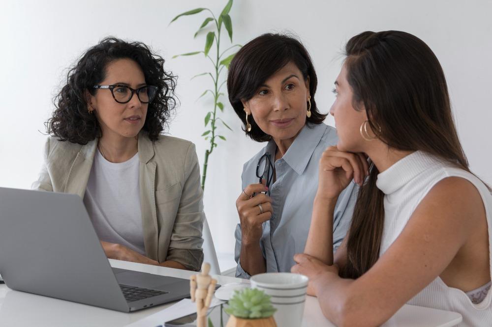 Tres mujeres hablando mientras se encuentran sentadas