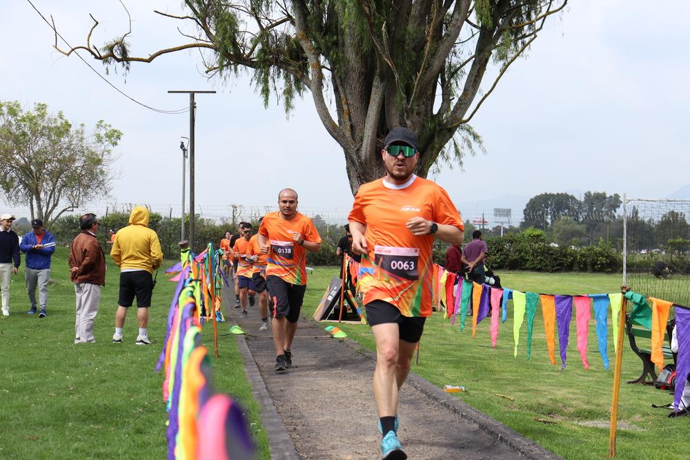 Foto de una persona corriendo en una maratón con una camiseta naranja