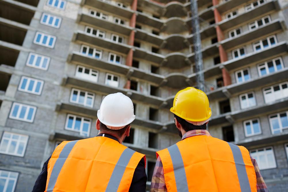 foto de dos arquitectos de espalda mirando  un edificio en construcción