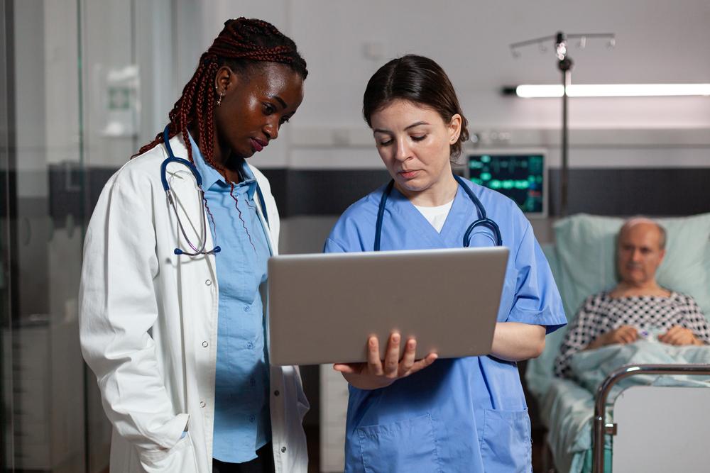 foto de un hombre y una mujer mirando un computador en una sala médica