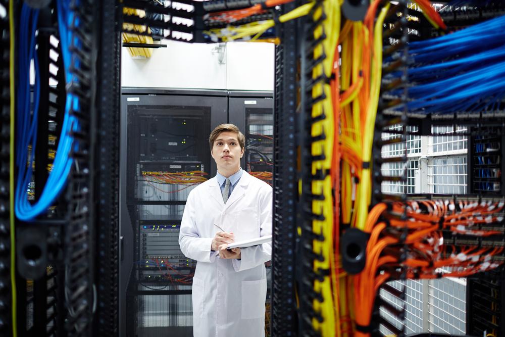 foto de un señor con bata frente a un computador grande