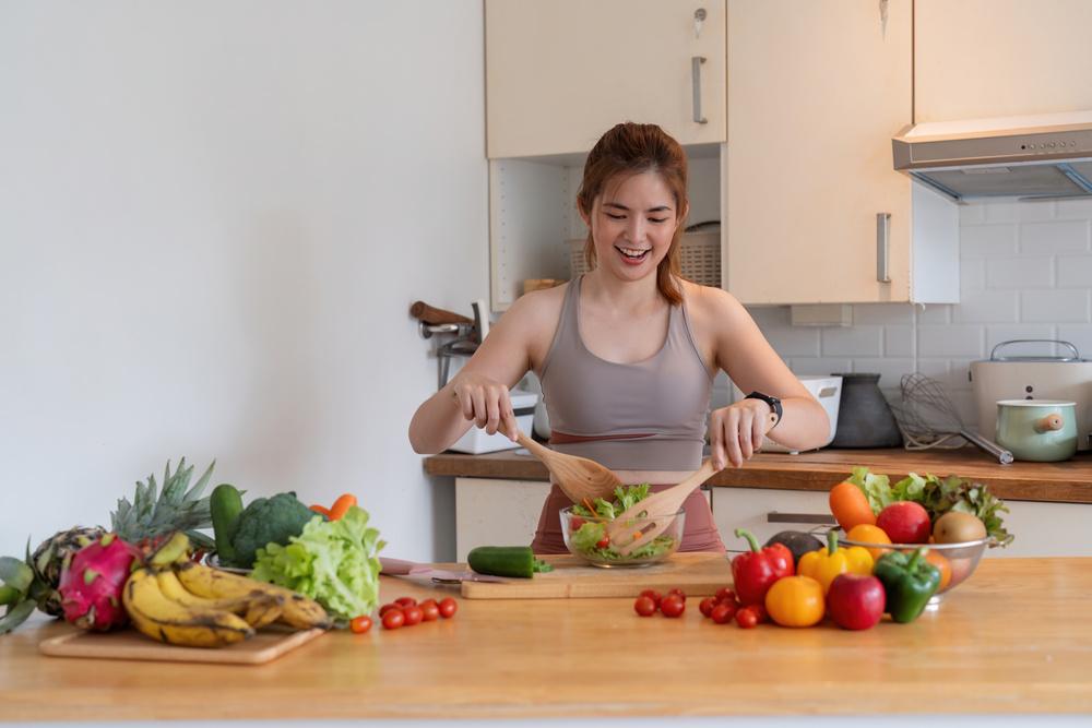 foto de una mujer preparando una receta con varias frutas al rededor