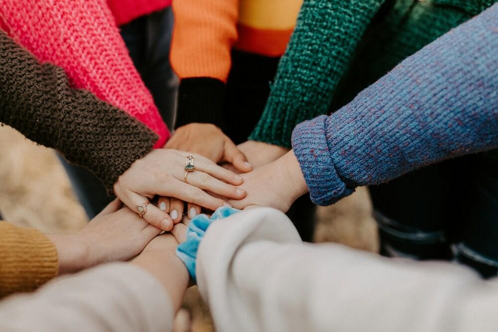 foto de varias personas poniendo su mano en el centro