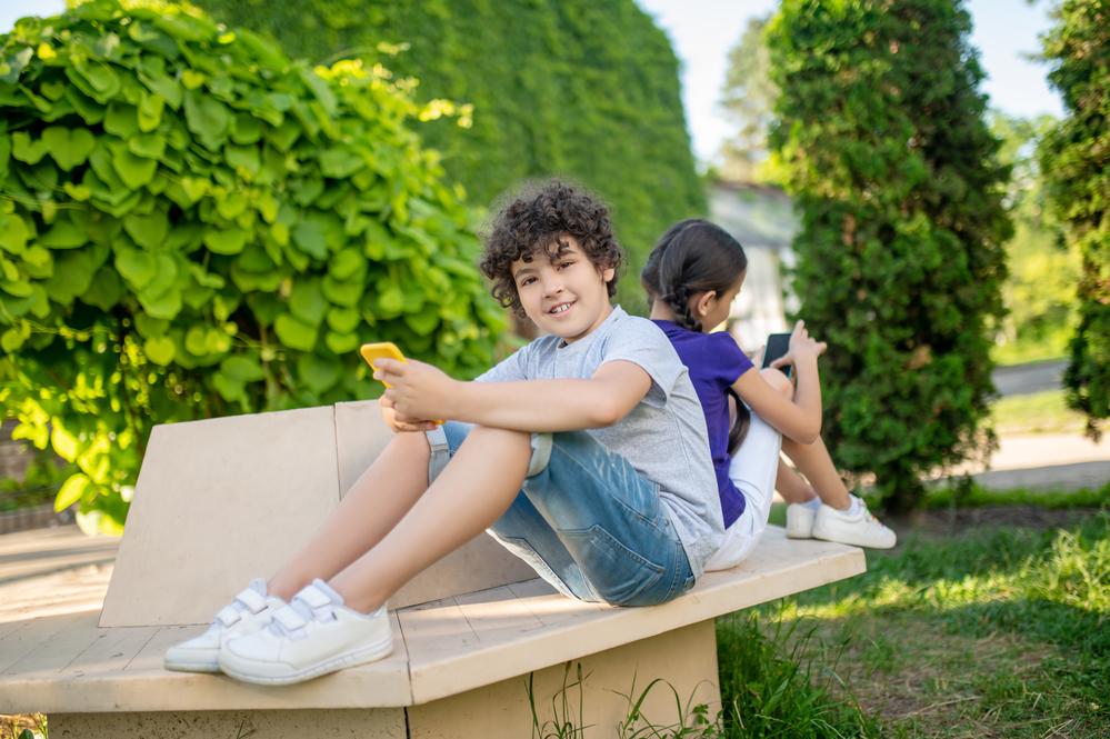 fotografía de dos niños con un celular en sus manos