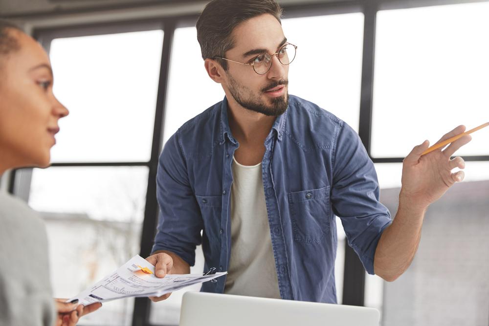 Hombre explicando un concepto a una colega en el trabajo