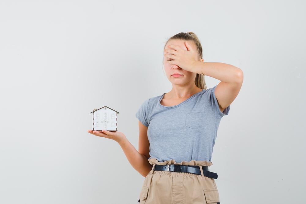 fotografía de una mujer sosteniendo un reloj y tapandose el rostro